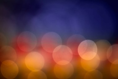Siyah bir arkaplan üzerine odaklanmış, renkli soyut bokeh.
