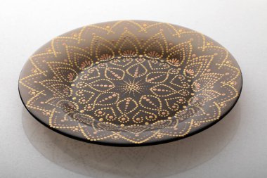 Kahverengi dekoratif plaka, beyaz arka planda, geometrik desenli..