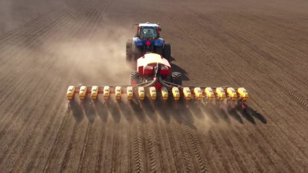 Tractor with seeder in the field, aerial view. — Stock Video