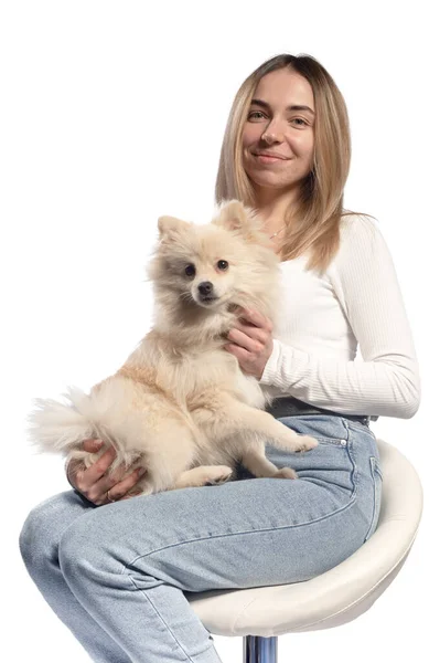 La chica sostiene un perro Spitz en sus brazos — Foto de Stock