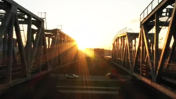 Σιδηροδρομική γέφυρα το ηλιοβασίλεμα, πτήσεις προς τον ορίζοντα την αυγή. — Αρχείο Βίντεο
