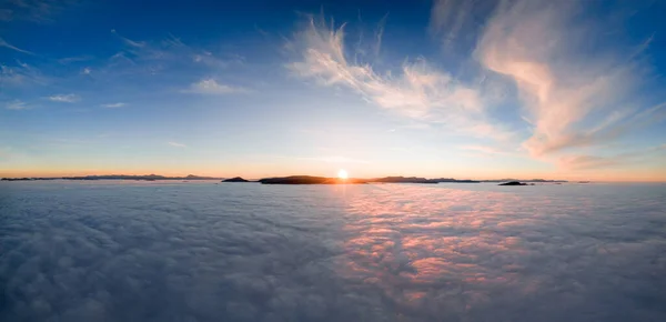 View from the drone at dawn over the clouds with mountains on the grassland. — Stock Photo, Image