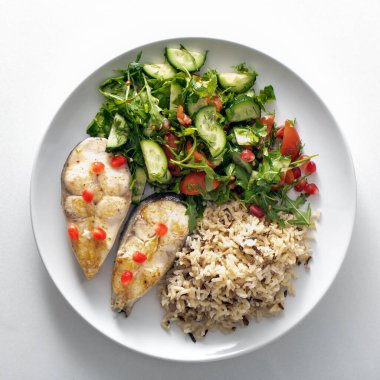 Fried trout. Wild whole grain rice porridge and salad. plate of healthy food