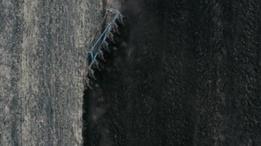 Bir traktörün tarlayı sürüşünün drone görüntüsü.