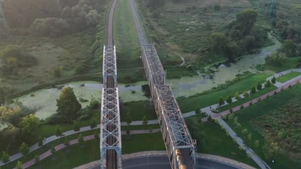 O trem atravessa a ponte ferroviária ao amanhecer. — Vídeo de Stock