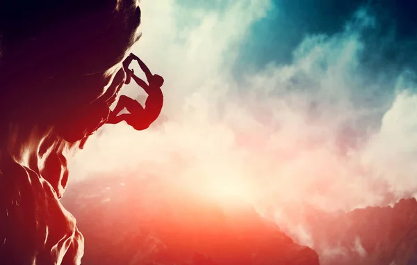 Kayaya tırmanan bir adam silueti.