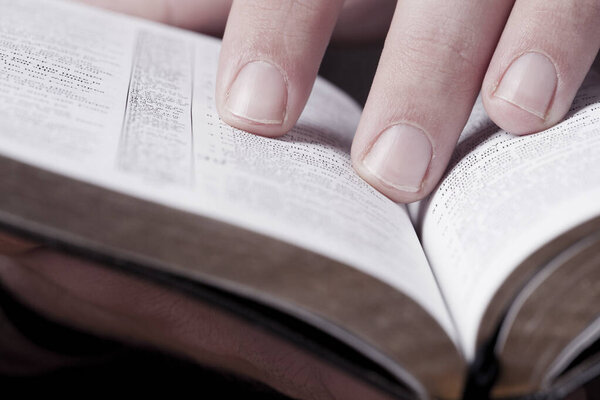 Close photo of man thumbing through the Bible