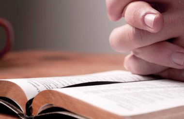 İncil için dua eden bir adamın elleri.