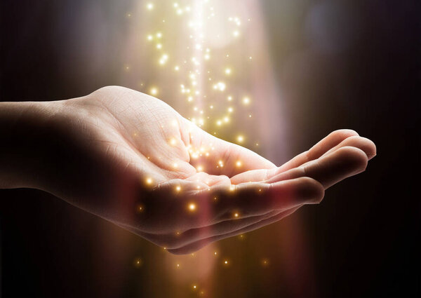 Stardust and magic in your hands. Magic particles on the palms of a hand