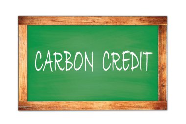Yeşil ahşap çerçeve okul tahtasına yazılmış CARBON CREDIT metni.