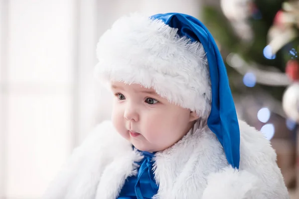 Noel ağacında hediyelerle Noel Baba gibi giyinmiş çocuklar.