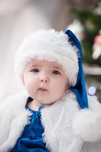 Noel ağacında hediyelerle Noel Baba gibi giyinmiş çocuklar.