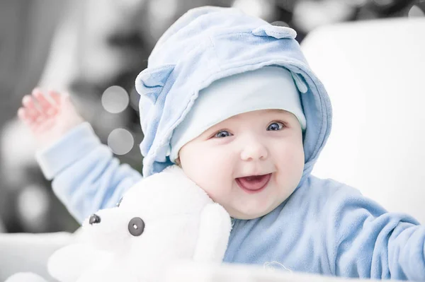 Noel ağacında hediyelerle Noel Baba gibi giyinmiş çocuklar.