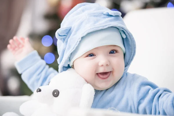 Noel ağacında hediyelerle Noel Baba gibi giyinmiş çocuklar.
