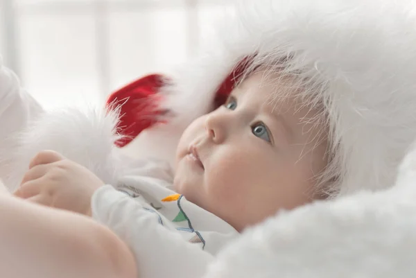 Noel ağacında hediyelerle Noel Baba gibi giyinmiş çocuklar.