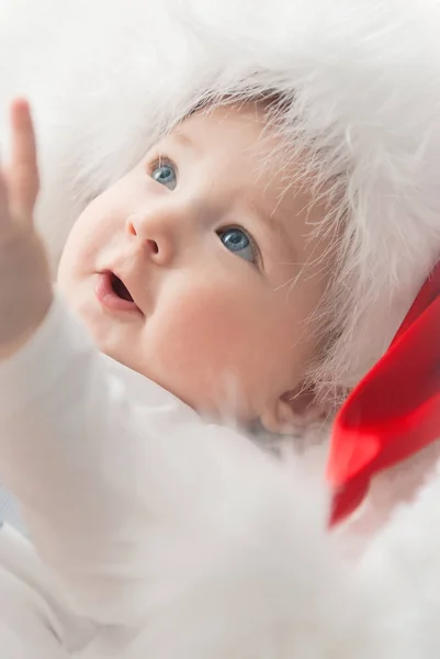 Noel ağacında hediyelerle Noel Baba gibi giyinmiş çocuklar.