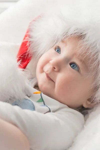 Noel ağacında hediyelerle Noel Baba gibi giyinmiş çocuklar.