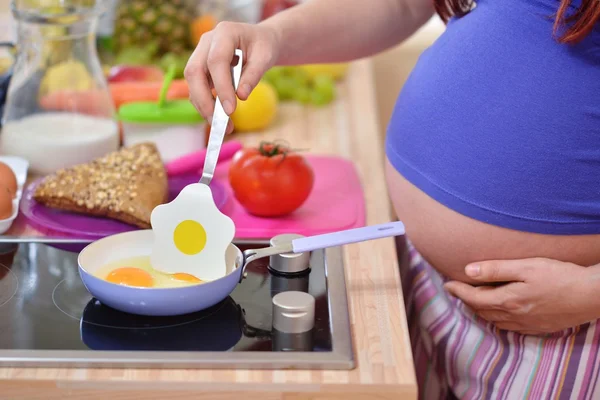 Pregnant woman prepares meal — Stock Photo, Image
