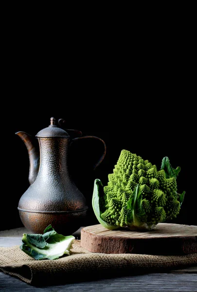 Romanesco lahanası, eskimiş sürahi ile karanlık bir havada.