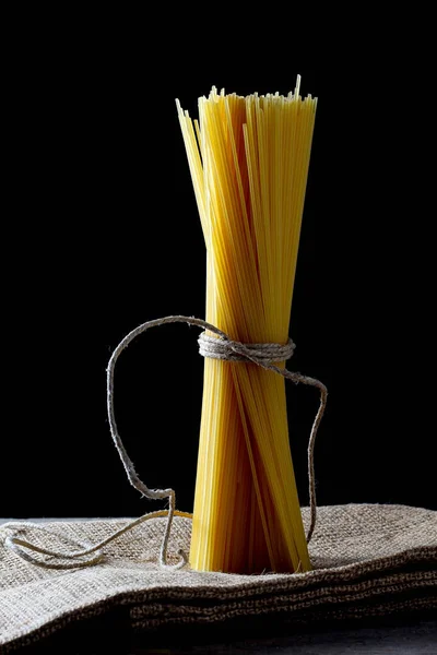 Bir demet spagetti jüt havlusuna bağlanmış sicimle kapkara bir hayat sürüyor.