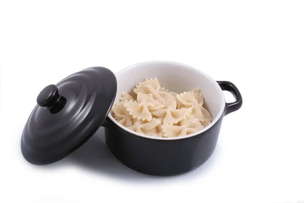 Beyaz arkaplanda izole edilmiş makarnalı siyah tava