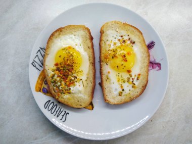 Baharatlı sahanda yumurta, somunda pişmiş.