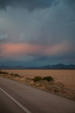 Çöl boyunca bulutlu gökyüzü olan güzel bir manzara. 
