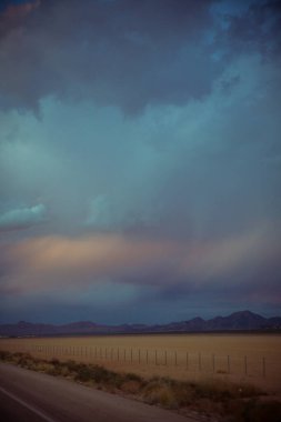 Çöl boyunca bulutlu gökyüzü olan güzel bir manzara. 