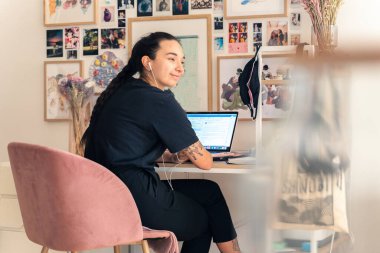 Ofisinde bilgisayarla çalışan genç bir kadın..