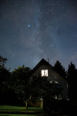 Geceleri gökyüzünün altında yıldızlarla dolu bir ev.