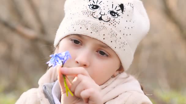 Menina cheirando gotas de neve azuis — Vídeo de Stock