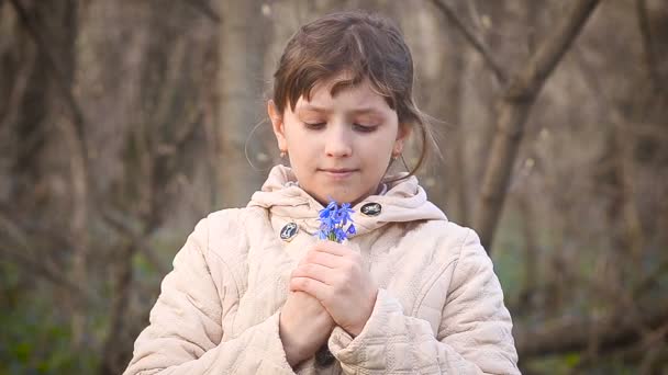 Fille recueille des gouttes de neige bleues dans la forêt 