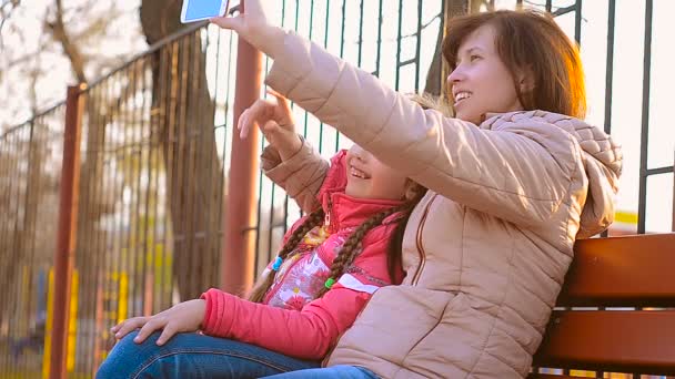 Uma mulher e sua filha fazendo selfie — Vídeo de Stock