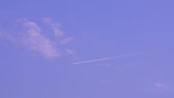 Flugzeug am blauen Himmel zeichnet Streifen — Stockvideo