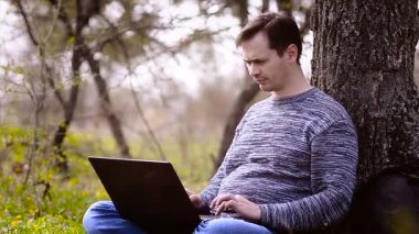 Bir adam bir bilgisayar ile oturma dayanmaktadır