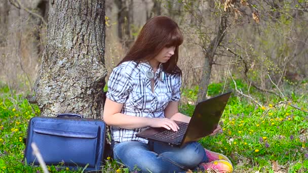 ノート パソコンに女の子が座っていると笑っています。 — ストック動画
