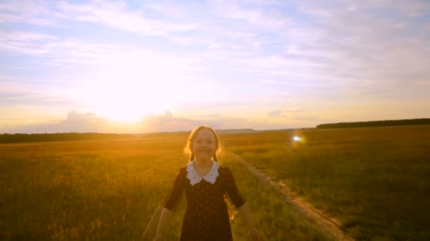Cheerful girl at sunset on the road running — Stock Video