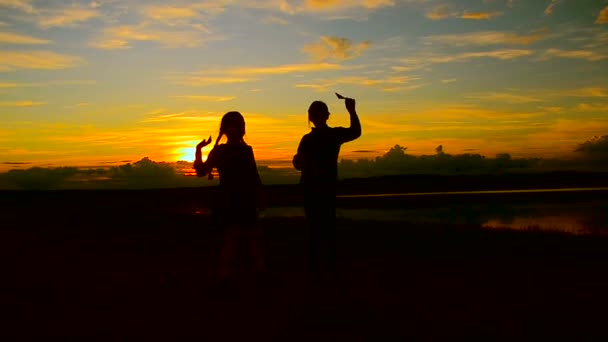 Los niños bailan en la hermosa puesta de sol ardiente — Vídeos de Stock