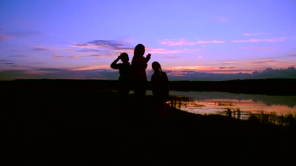 Les enfants avec la mère font selfie téléphone au coucher du soleil — Video