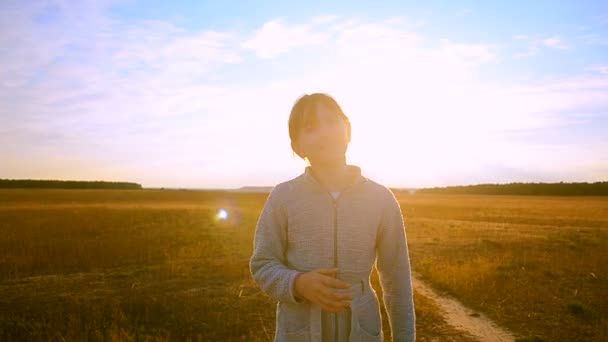 Ragazza contro il tramonto è sulla strada e guardando indietro ridendo — Video Stock