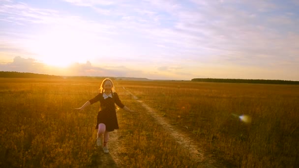 Chica alegre al atardecer en el camino corriendo — Vídeos de Stock