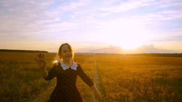 Cheerful girl at sunset on the road running — Stock Video