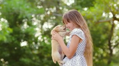 Kız bir köpek yavrusu ellerde dönüyor.