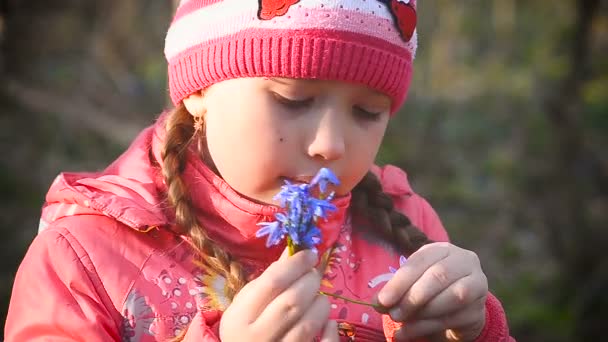 Girl sniffing blue snowdrops