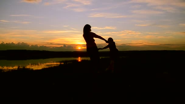 Kinder mit Mutter wirbeln bei Sonnenuntergang am Ufer — Stockvideo