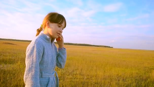 Fille sur un fond de ciel bleu sont sur la route et parler au téléphone — Video