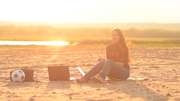 Het meisje verwacht een gesprek via de telefoon — Stockvideo