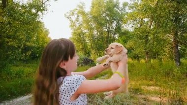 Kız bir köpek yavrusu ellerde dönüyor.