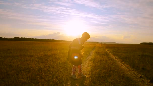 Fille sur le fond coucher de soleil avec la tablette est rayé — Video