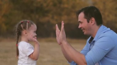 Babam küçük kızıyla el ele oynuyor. Baba ve sevgili çocuk birlikte eğlenin. Mutlu aile kavramı. Takım çalışması. Kid ve adam parkta çok eğleniyorlar. Doğa yürüyüşleri.